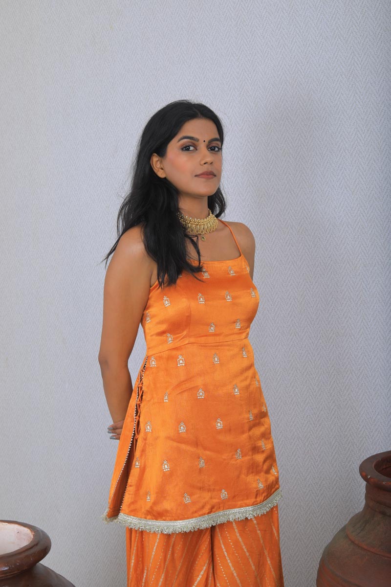 Girl wearing a traditional Orange Palazzo Set with a white dupatta