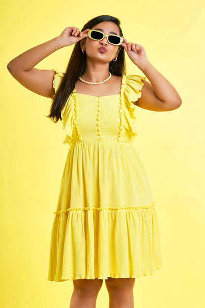 Girl wearing a Ruffled Yellow Dress showing it off in style