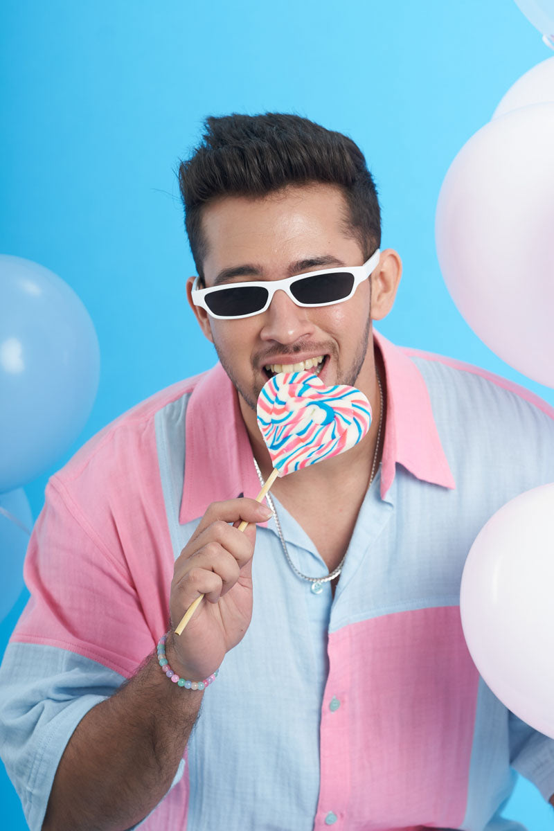 Guy wearing a Unisex Loungewear Oversized Shirt with patch fabrics of Pink and Blue