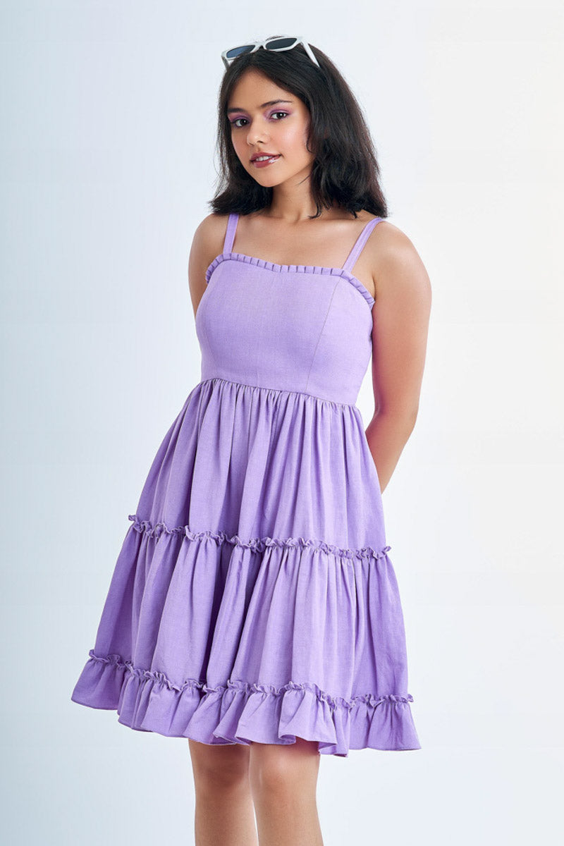 Girl wearing a lavender tiered loungewear dress with glasses set in her hair